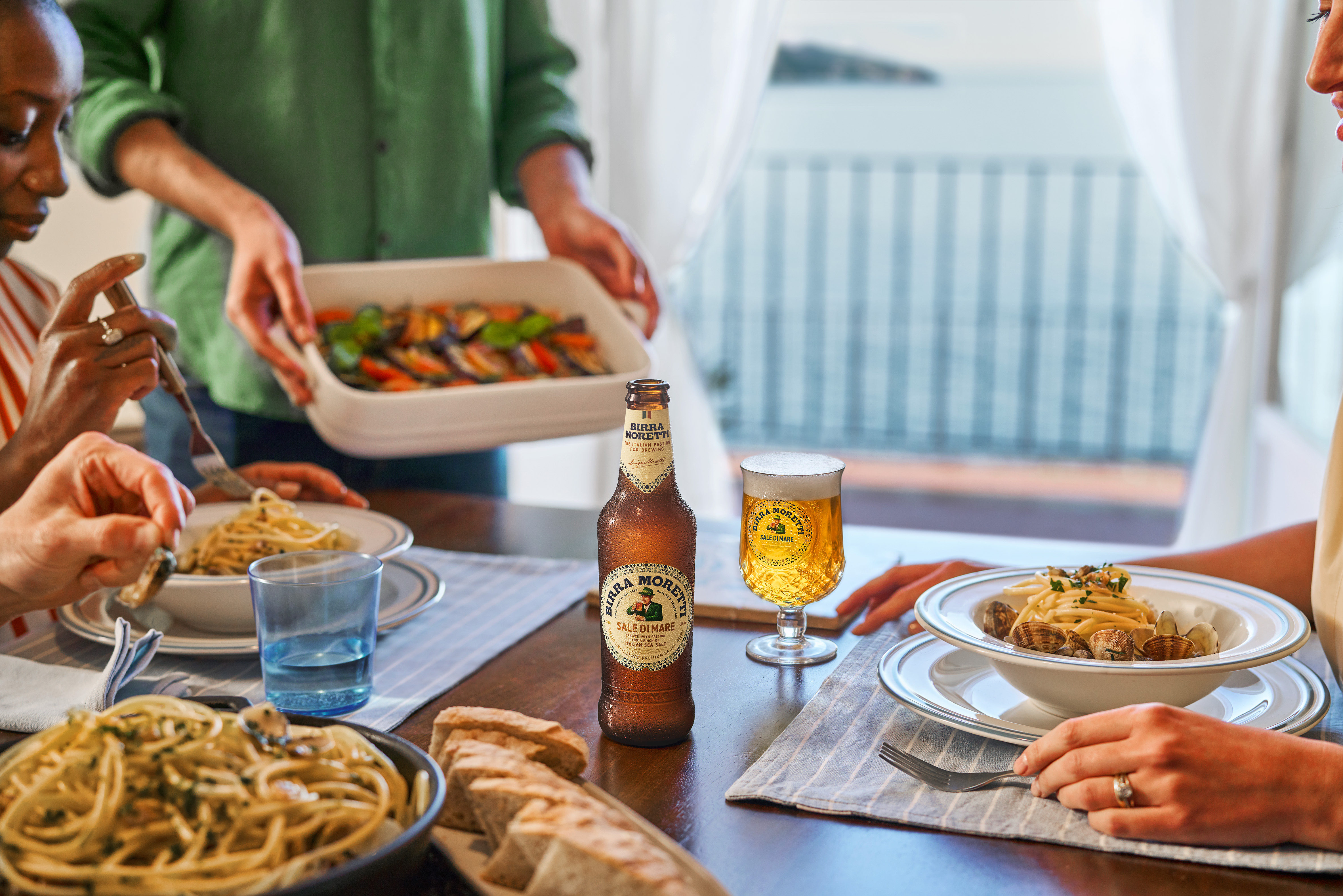 A table filled with food, with people sitting around it and eating,